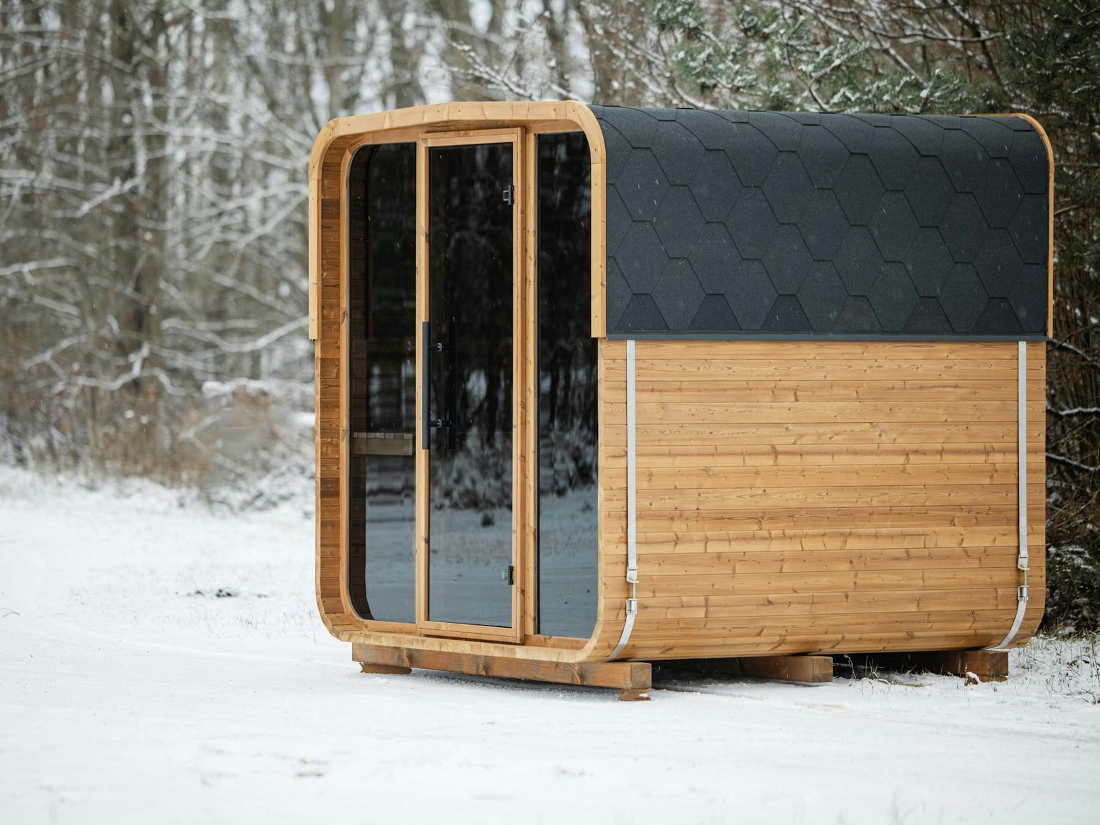 A compact timber cabin unit standing in snow